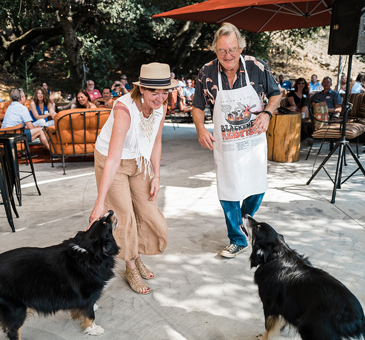 Two people playing with dogs at B.Wise outdoor event