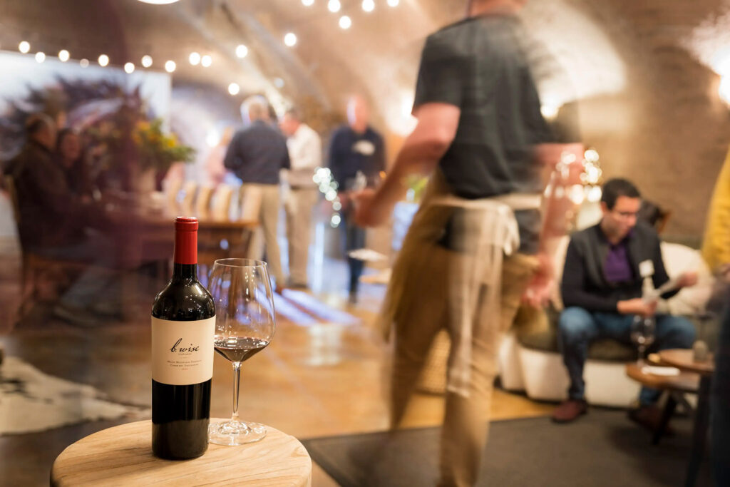 b. wise club members in cave with bottle of wine in the forground