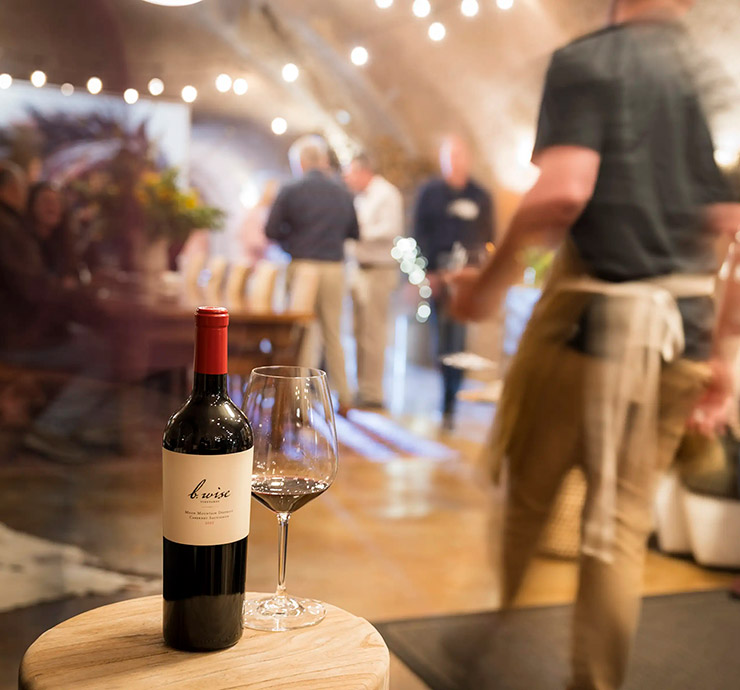 b. wise club members in cave with bottle of wine in the forground