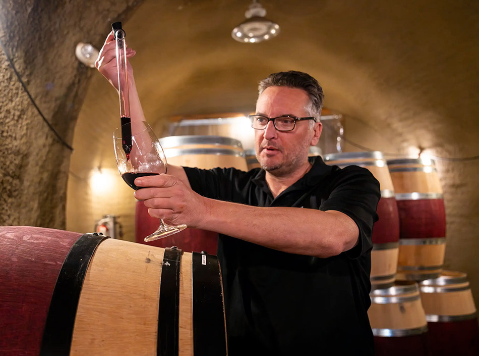 b. wise club - winemaker sampling wine from barrel