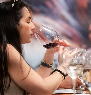 b. wise wine club member smelling wine in wine glass