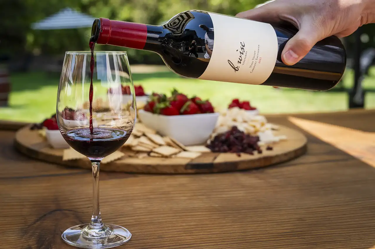 outside of the Kenwood Tasting Lounge with glass of wine and charcuterie plater on a table